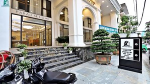 A hotel entrance with a marble staircase, a reception area, and a signboard for serviced apartments. - Luxe Paradise Suites Tay Ho (Hanoi)