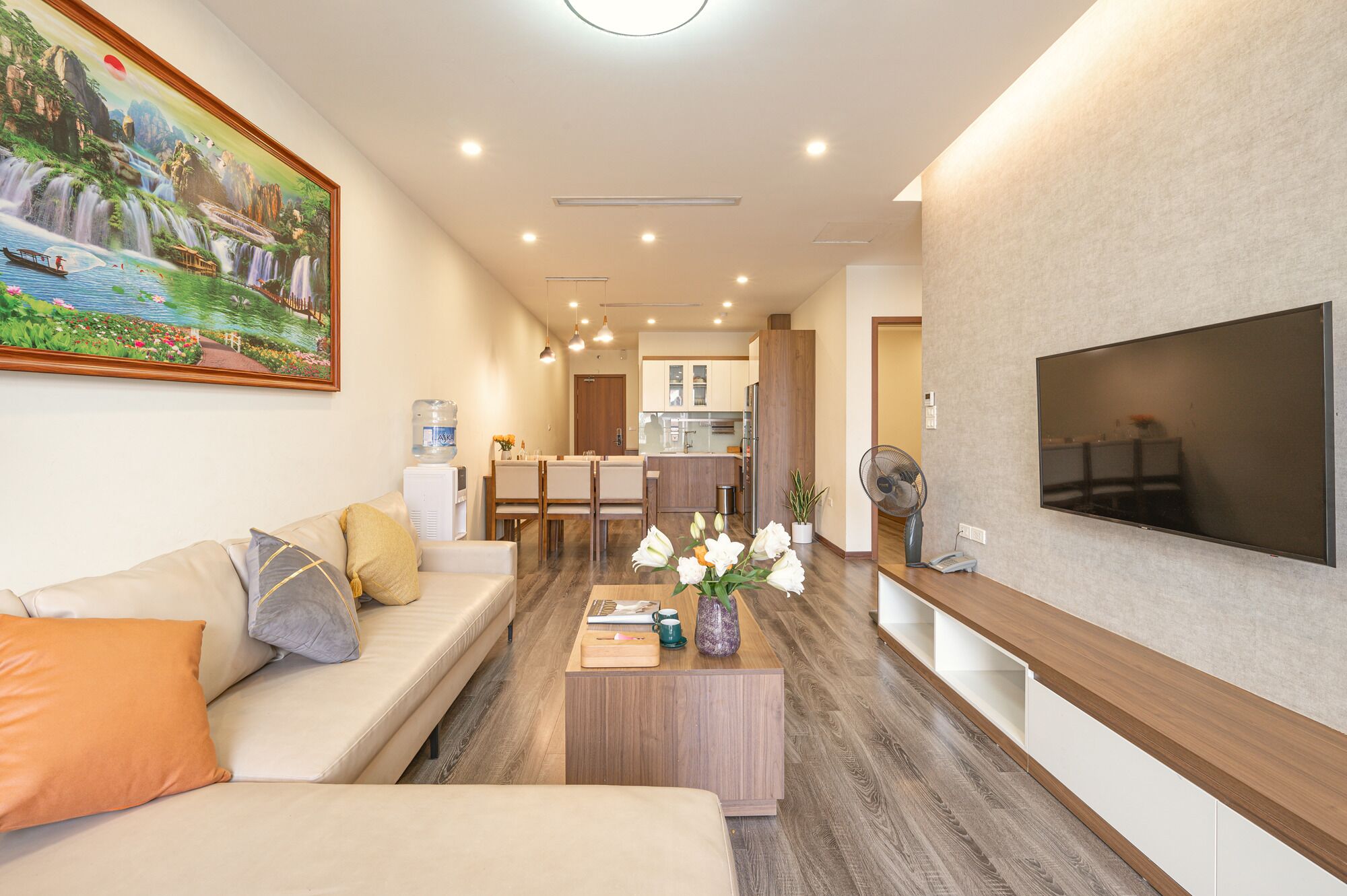 Una sala de estar moderna con un sofá, una mesa de centro y un televisor montado en la pared.