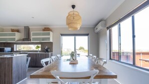Una cocina moderna con zona de comedor, ventanas amplias y vistas al exterior.