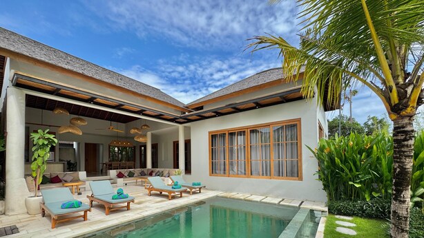 Une maison moderne dotée d’une piscine, d’un espace salon extérieur et d’une végétation luxuriante.