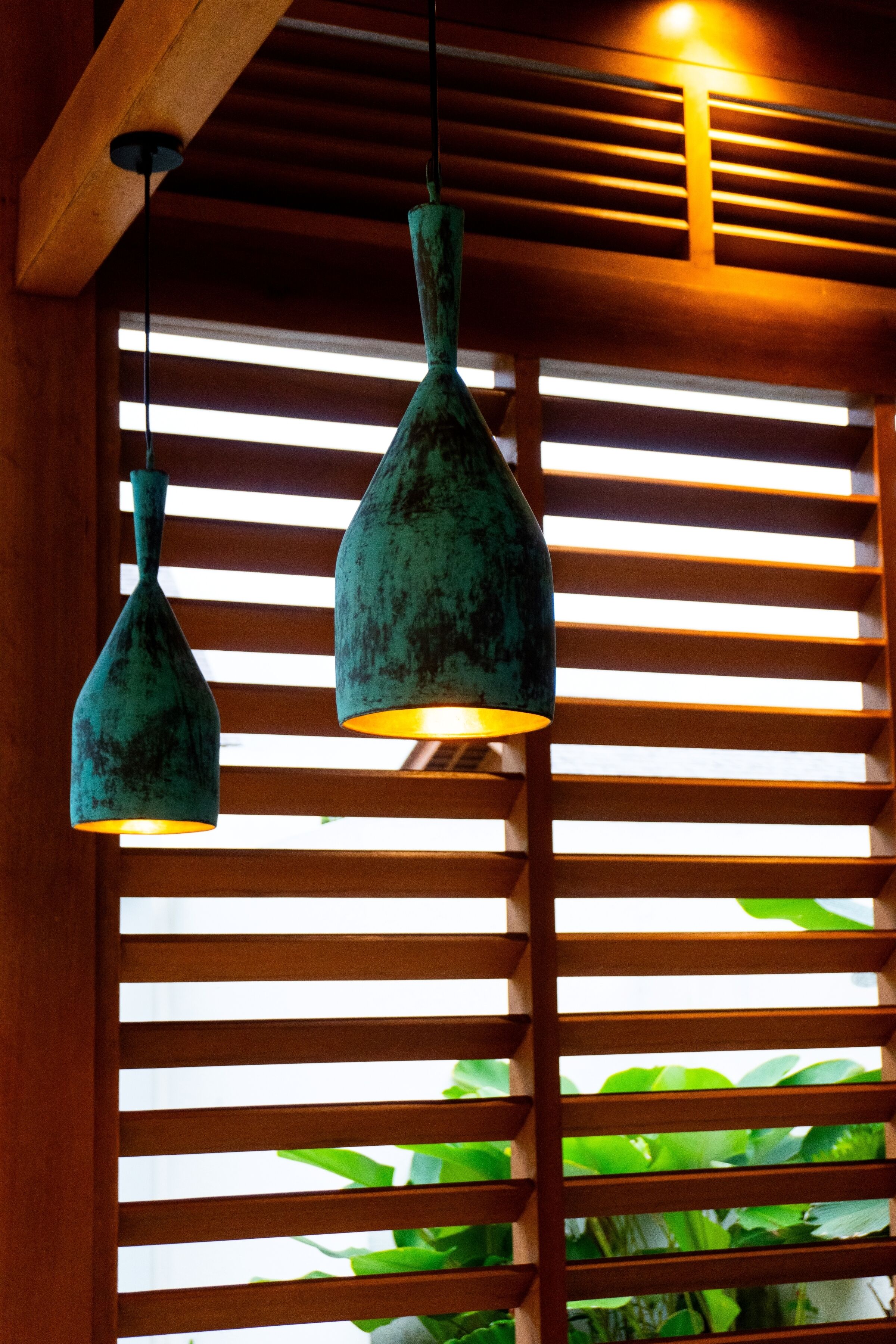 A room with wooden slats and hanging pendant lights.