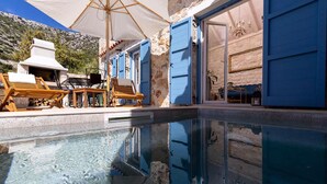 An infinity pool with wooden lounge chairs and a white umbrella. - 3 bedroom stunning home in Zarace (Zarace)
