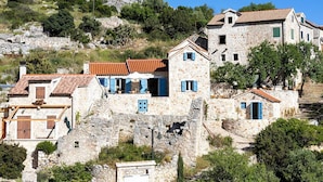 A stone building with a red-tiled roof, blue shutters, and a stone staircase leading up to it. - 3 bedroom stunning home in Zarace (Zarace)