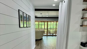 En hall med trägolv, vita väggar och en vit soffa i bakgrunden.