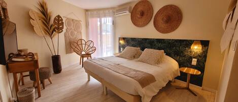 Un dormitorio con cama, mesita de noche, lámpara y decoración mural.