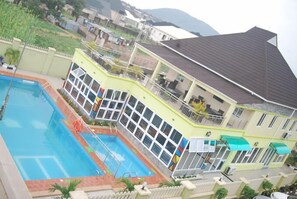A two-story building with a swimming pool, large windows, and a balcony. - Aaliyah Royale Hotel (Abuja)