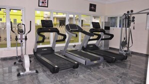 A gym with treadmills, an elliptical, and a weight machine. - Aaliyah Royale Hotel  (Abuja)