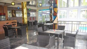 A restaurant with wicker furniture, marble flooring, and large windows. - Aaliyah Royale Hotel  (Abuja)