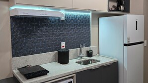Una cucina moderna completa di forno a microonde, macchina del caffè e frigorifero.