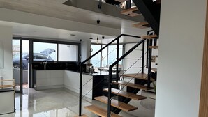 Una cucina moderna con una scala nera che conduce a una zona pranzo.