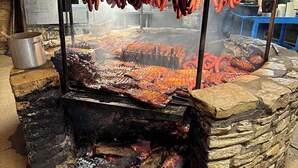 Ein traditioneller Backofen aus Stein mit Metalldeckel, zum Braten von Fleisch.