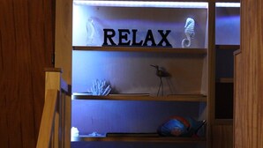 Ein Regal mit dem Wort 'RELAX' und dekorativen Gegenständen, darunter ein Seepferdchen und ein Vogel.