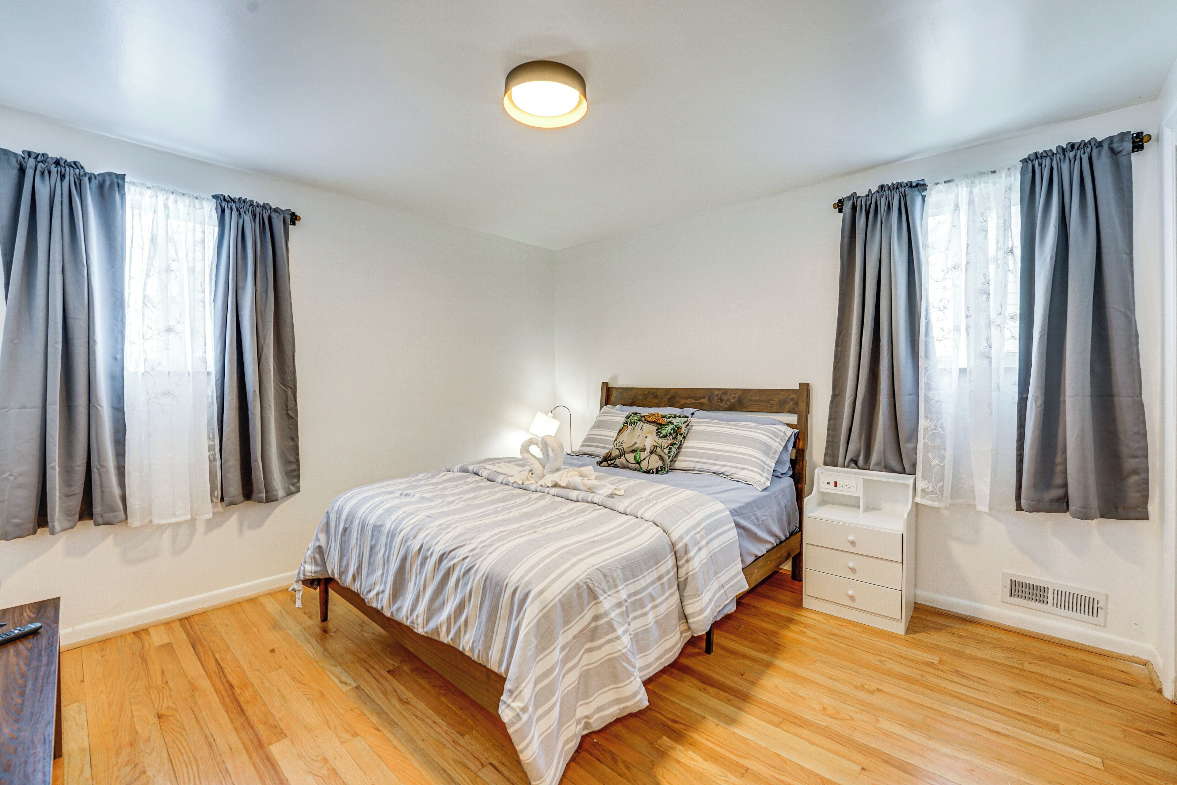 A bedroom with a bed, bedside table, and curtains.