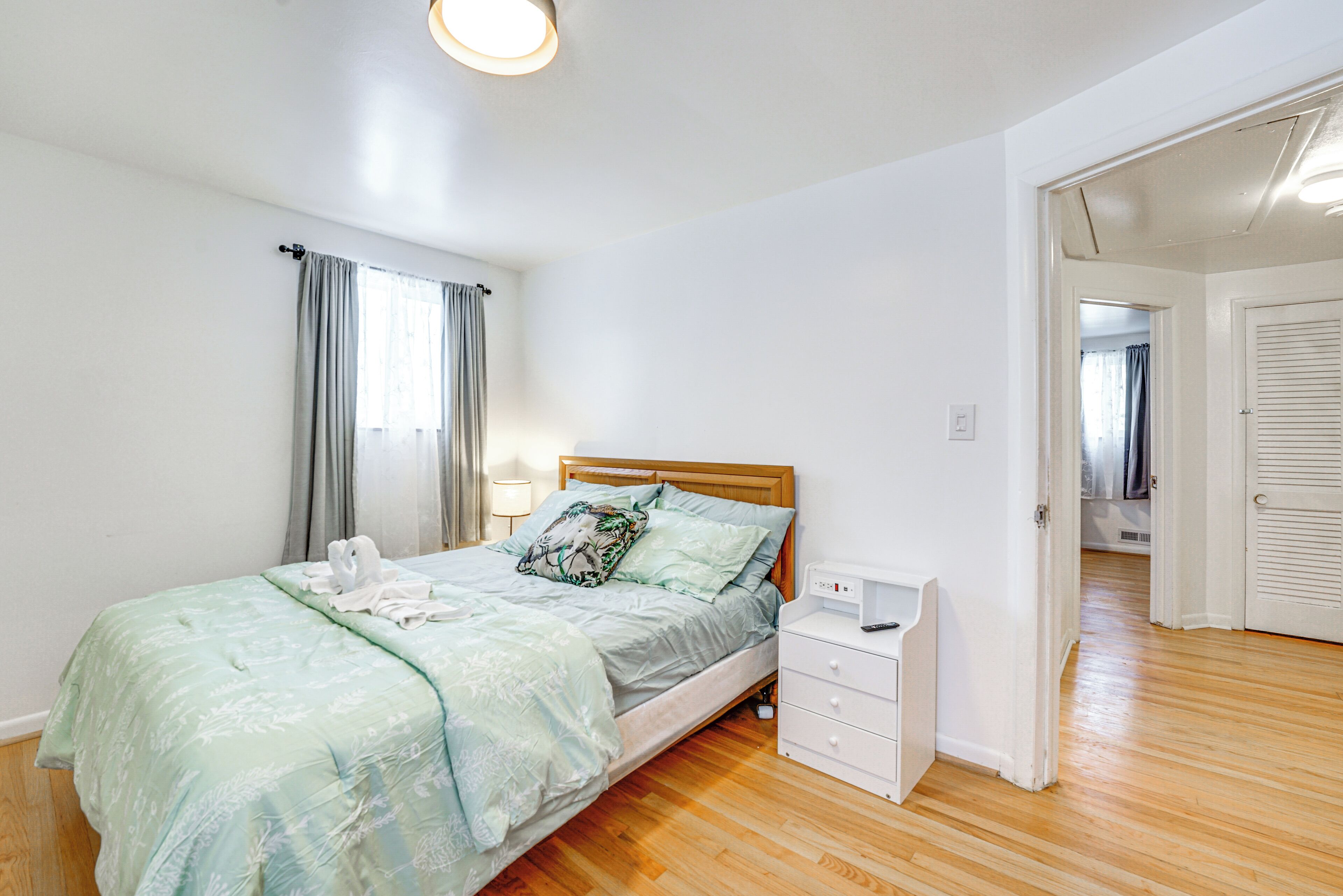 A bedroom with a bed, bedside table, and a walk-in closet.
