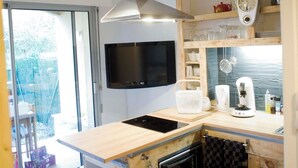 A modern kitchen with a wooden countertop, built-in oven, and a black range hood.