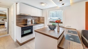 Een moderne keuken met witte kastjes, een houten aanrecht en een inbouwoven.