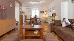 Ein Wohnzimmer mit Sofa, Couchtisch und einem Essbereich mit Stuhl und Tisch.