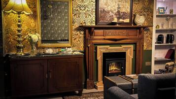 Un salon chaleureux avec une cheminée, un meuble en bois et une lampe.