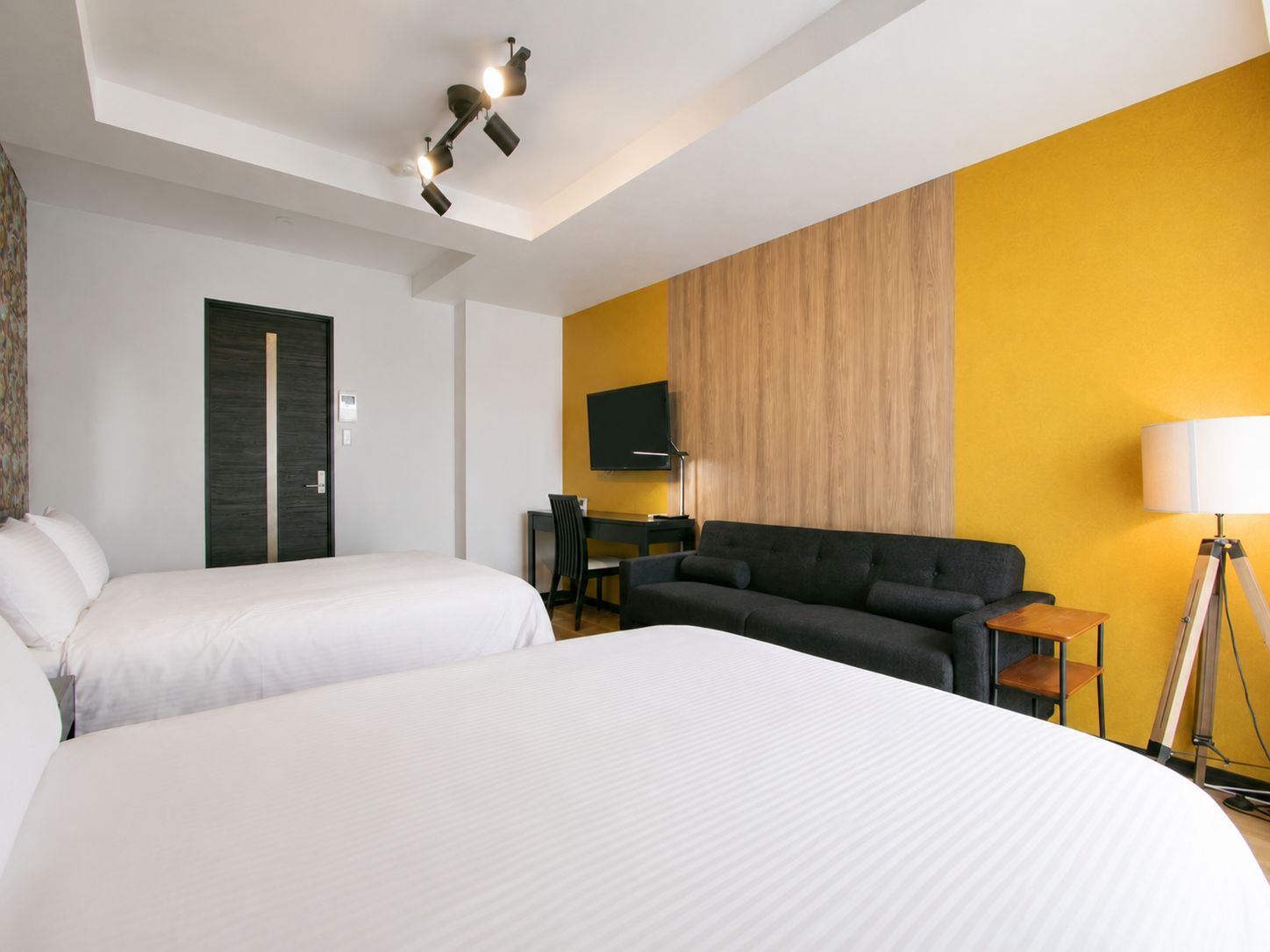 Une chambre d’hôtel avec un grand lit, un canapé, un bureau et une télévision.