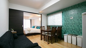 A compact hotel room with a bed, a small dining table with chairs, a sofa, and a kitchenette area. - Randor Residence Tokyo Annex (Tokyo)