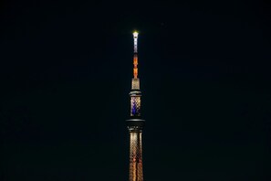 A tall, illuminated tower with a spire at the top, set against a dark night sky. - Randor Residence Tokyo Annex (Tokyo)