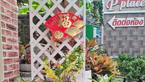 A storefront with a sign that reads "Place" and a decorative red and gold sign above a white lattice structure. - Pplace (Bangkok)