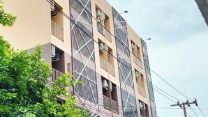 A multi-story building with a modern architectural design, featuring balconies and a prominent entrance. - Pplace (Bangkok)