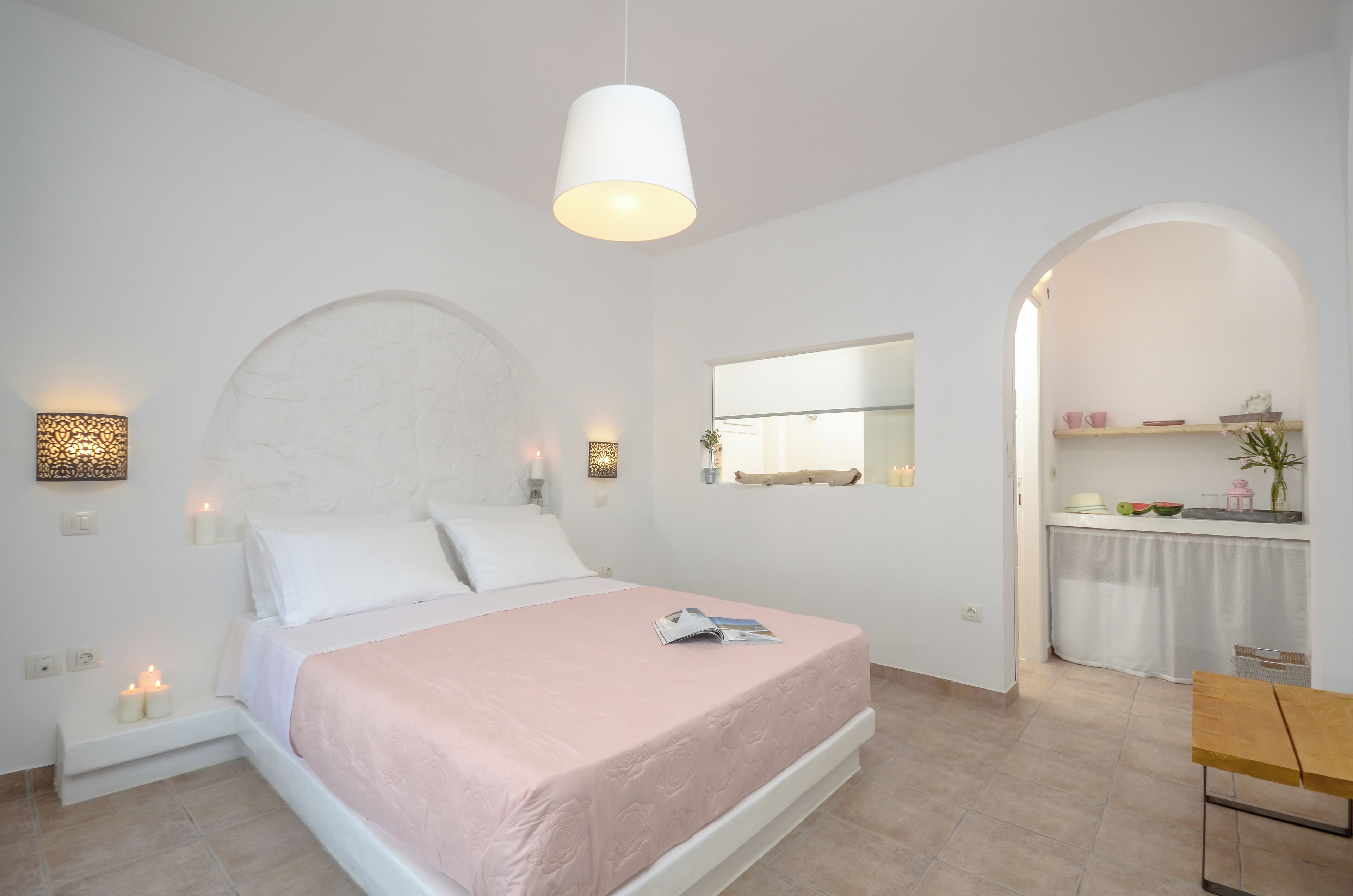 Ein modernes Schlafzimmer mit einem großen Bett, einem Nachttisch, einer Hängelampe und einem kleinen Tisch mit einem Stuhl.