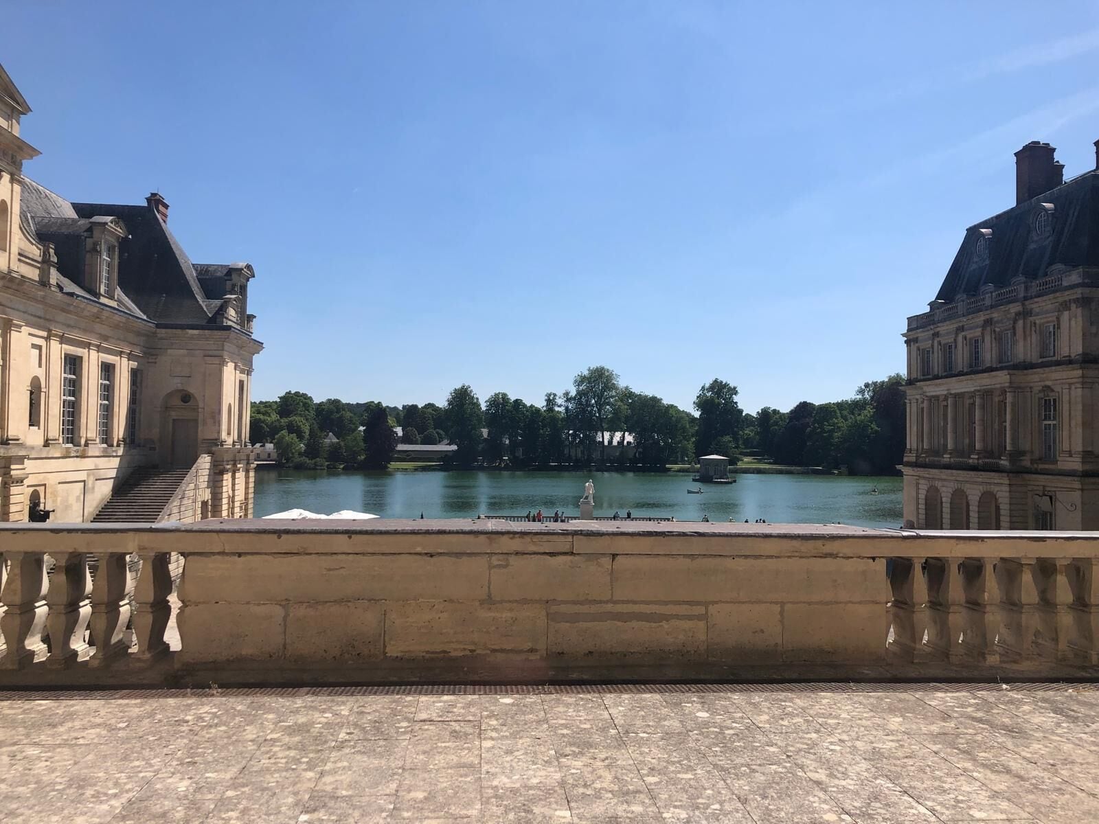 Ein historisches Gebäude mit klassischer Architektur, einem großen Innenhof und einem Fluss im Hintergrund.