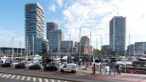 A marina with modern buildings, boats, and a pedestrian walkway. - Apartment With a View of the Marina (Ostend)