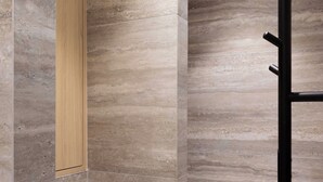 Un baño moderno con zona de ducha, paredes con azulejos y un armario de madera.