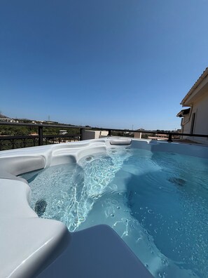 A hot tub with a clear view of the surrounding landscape and a building in the background. - Papyrise View (Heraklion)