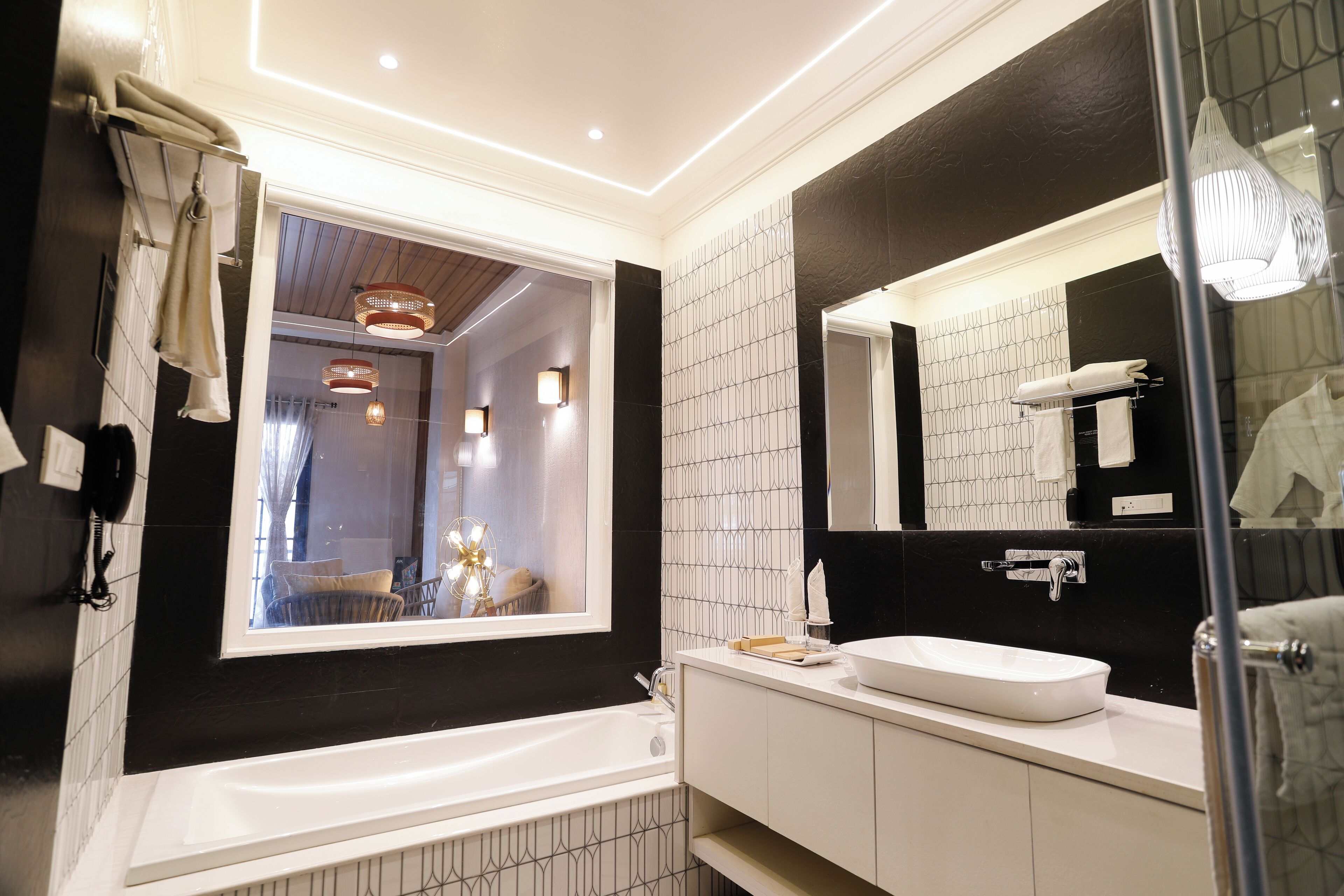 Une salle de bain moderne avec une grande fenêtre, une baignoire, un lavabo et un miroir.