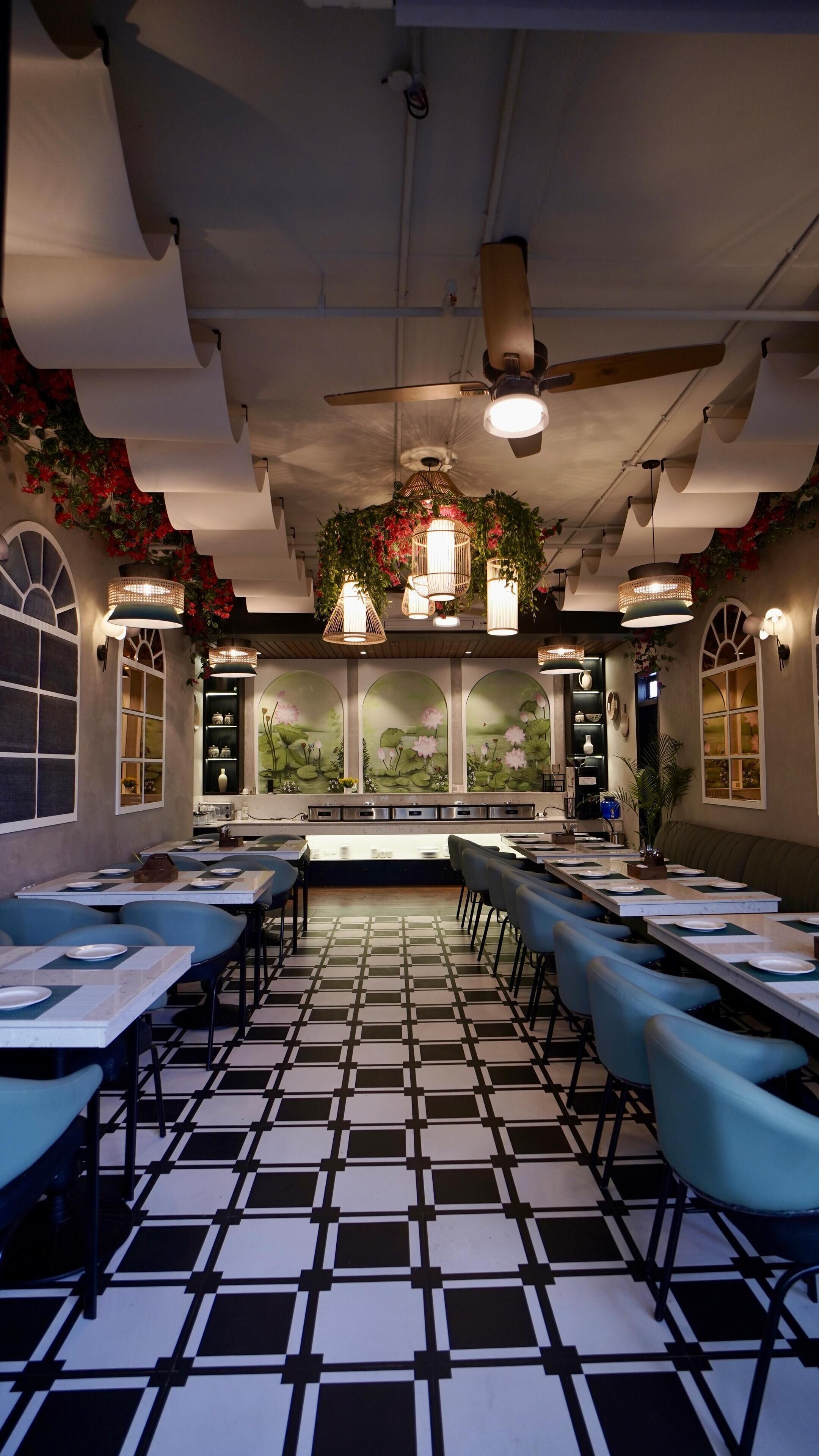 Un restaurante con suelo a cuadros, mesas largas y sillas azules.