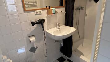 Een haardroger, handdoeken, zeep, toiletpapier