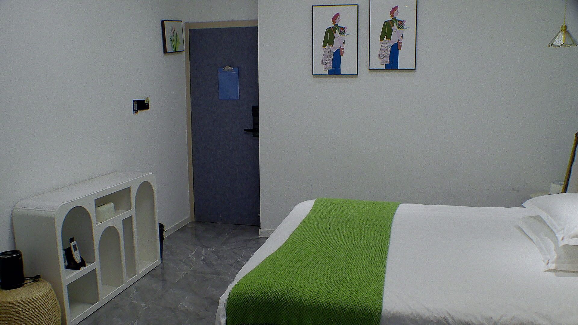 Une chambre d’hôtel comprenant un lit, un petit coin salon et une porte donnant sur une autre pièce.