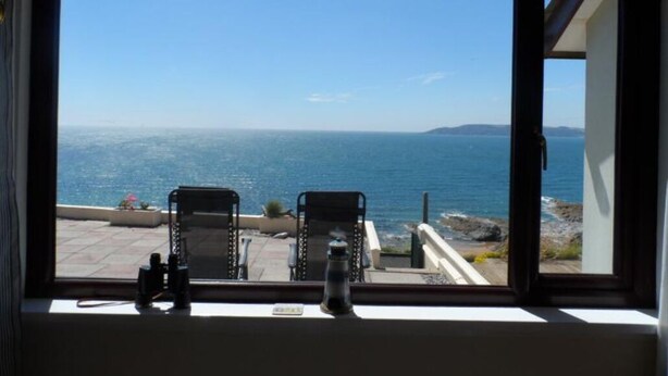Une pièce dotée d’une grande fenêtre donnant sur une vue imprenable sur la côte.