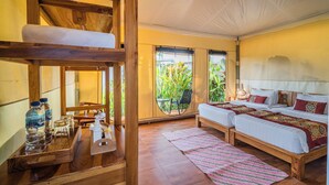A room with two beds, a wooden bench, a tray with water bottles, and a view of greenery outside. - Paddy's Glamping (Munggu)
