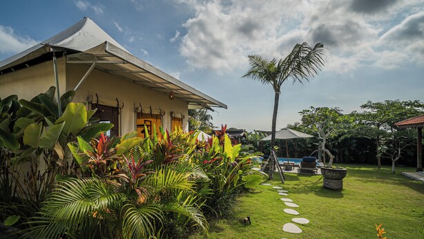 A house with a garden, a pool, and a stone pathway. - Paddy's Glamping (Munggu)