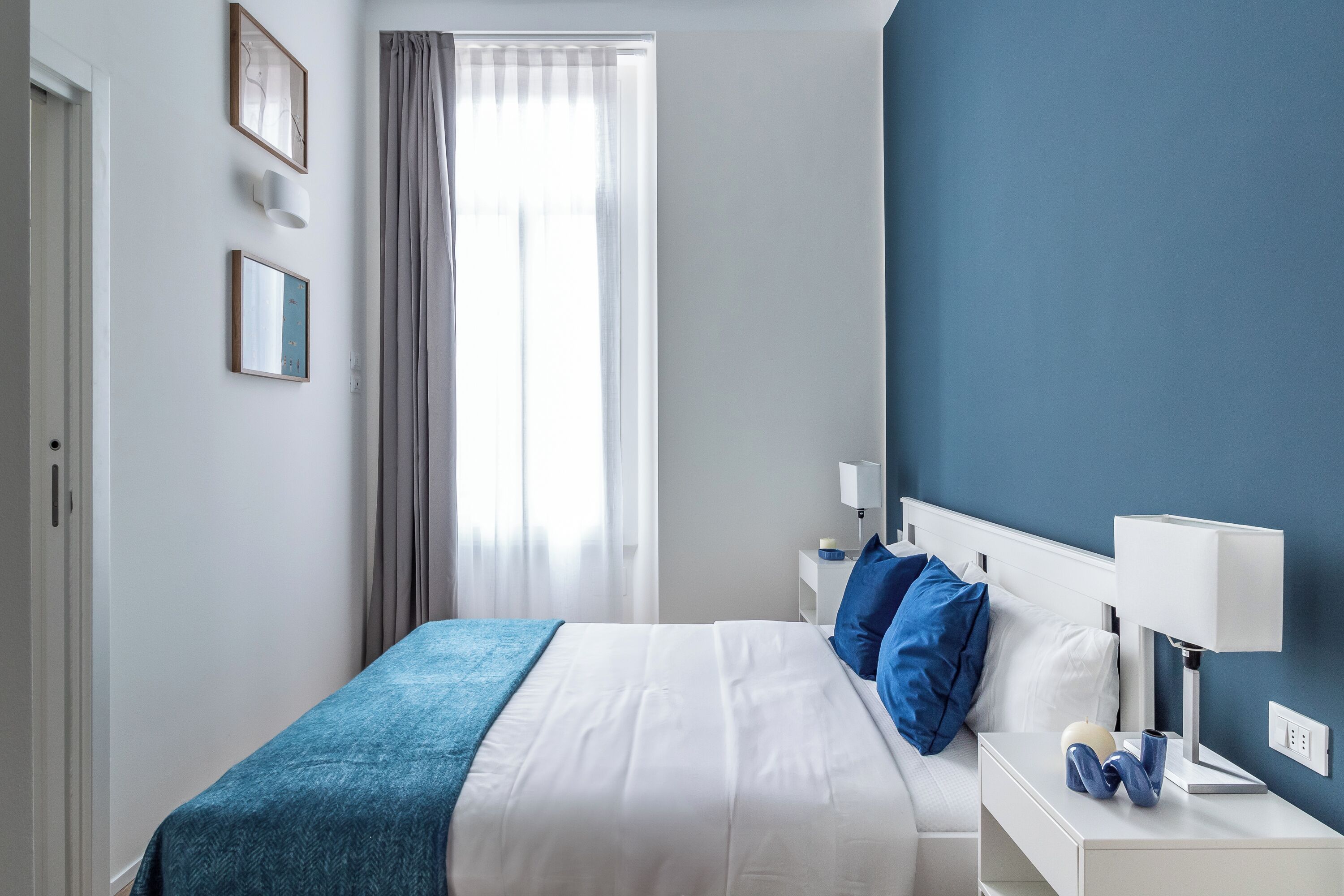 Una camera da letto con un letto, comodini e un tavolino di fianco al letto.