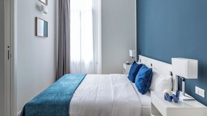 Un dormitorio con cama, mesitas de noche y una mesilla.