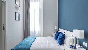 Una camera da letto con un letto, comodini e un tavolino di fianco al letto.