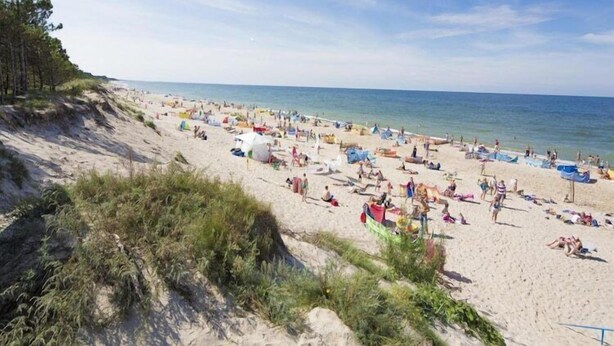 En strand med många tält och en stor mängd människor.