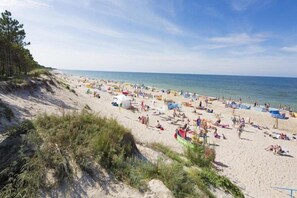 A beach with numerous tents and people. - Comfortable holiday homes with a summer pool (Darlowo)
