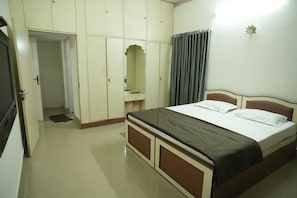 A bedroom with a bed, wardrobe, and a mirror. - Heritage Garden Villa (Mangaluru)