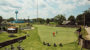 Un parcours de golf doté d’un château d’eau, d’un espace pique-nique et d’une clôture en bois.