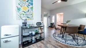 A modern kitchen with a coffee machine, microwave, and a black shelf with glassware. - Three Oaks Unit Steps To Downtown! 2 Night Summer Min! (Three Oaks)