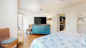 A bedroom with a bed, a television, a cabinet, and a chair. - Beautiful Forest Beach Villas couple's retreat. 5 min walk to Coligny Beach (Hilton Head Island)