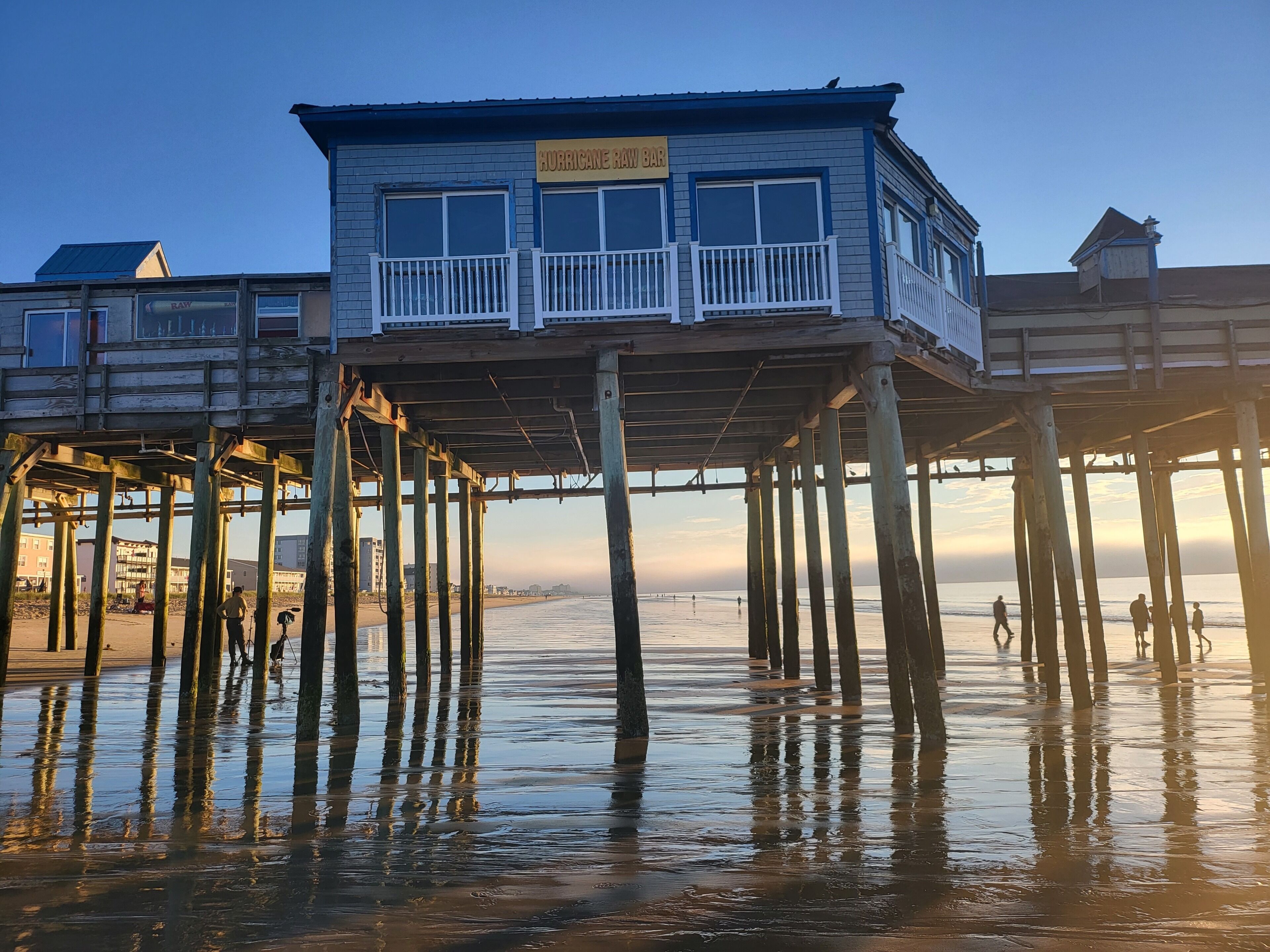 A wooden pier with a bar named Hurricane Raw Bar at the top.