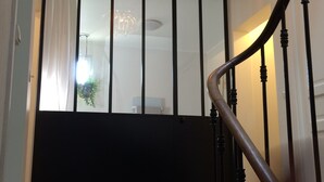 Un escalier avec une main courante en bois et une rampe noire.